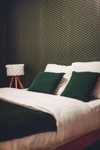uma cama com almofadas verdes num quarto em Villa 4ch 4Sdb à 5min de Nantes em Sainte-Luce-sur-Loire