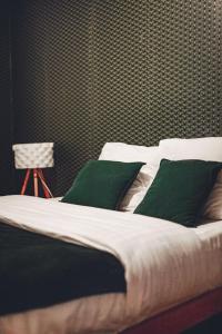a bed with green pillows in a bedroom at Villa 4ch 4Sdb à 5min de Nantes in Sainte-Luce-sur-Loire