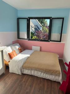 a bedroom with a large bed and two windows at Villa 4ch 4Sdb à 5min de Nantes in Sainte-Luce-sur-Loire
