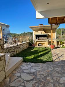 a patio with a stone wall and a grill at Nice Cosy apartment in Igoumenitsa in Igoumenitsa