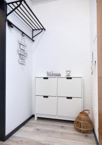 uma cómoda branca num quarto com uma parede branca em Entdecke das idyllische Allgäu - Verbringe deinen Traumurlaub in unserer gemütlichen Ferienwohnung em Immenstadt im Allgäu