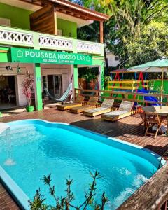 a resort with a swimming pool and a playground at POUSADA NOSSO LAR in Guarujá