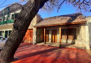a building with a gate next to a tree at Departamento en el Centro de Mendoza, Parking Gratis, Check-in Autónomo in Mendoza