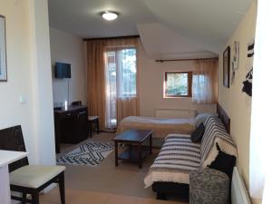 um quarto de hotel com uma cama e um sofá em Конна база и Къща за гости Дворене em Razlog