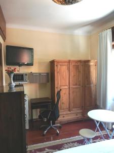 um quarto com uma secretária, uma cadeira e uma televisão em Private Room in Beautiful Home em Montevidéu