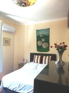 ein Schlafzimmer mit einem Bett und einer Vase aus Blumen auf einem Tisch in der Unterkunft Private Room in Beautiful Home in Montevideo