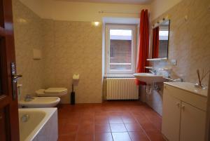 ボルミオにあるCasa Bellottiのバスルーム(洗面台2台、トイレ、バスタブ付)