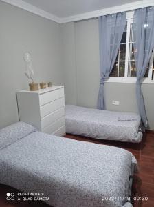 a bedroom with two beds and a window at La viña in Melilla