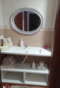 ein Bad mit einem Waschbecken und einem Spiegel in der Unterkunft La viña in Melilla