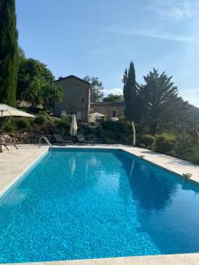 a large blue swimming pool in front of a house at Magnifique Mas Cevenol in Anduze