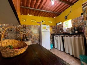 eine Küche mit einem Tisch und einem weißen Kühlschrank in der Unterkunft Casa dos franceses guesthouse ilha grande in Abraão