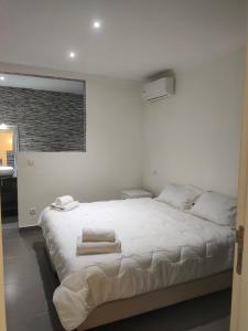 a white bedroom with a large bed with towels on it at Villa Sara avec sa piscine et jardin in Marrakesh