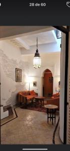 a living room with a couch and a table at Riad au cœur de la médina loué entièrement avec ménage et petit déjeuner compris in Marrakech