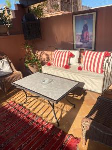 d'une terrasse avec un canapé et une table basse. dans l'établissement Riad au cœur de la médina loué entièrement avec ménage et petit déjeuner compris, à Marrakech