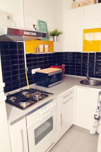 a kitchen with a stove and a microwave at Trendy & Cozy Apartment at Heroes' Square in Budapest