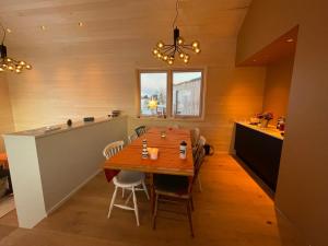a dining room with a table and a kitchen at Superior Cabin with Private Beach Lofoten 