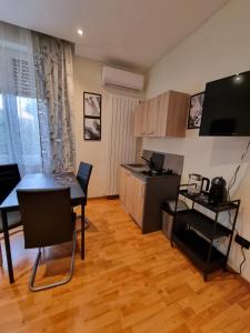 uma sala de estar com uma mesa e uma cozinha em Alloggio Silva em Gorizia