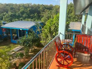 a balcony with a red bench and a table on it at Twocans Homestay KohMak - SHA in Ko Mak