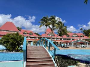 圣安尼Village Vacances Sainte Anne - Vue exceptionnelle Piscine et Plage Vue mer - Barbadine 1010 by Studios Barbadine的通往带游泳池的度假胜地的木桥