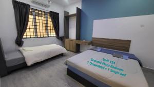 a bedroom with two beds in a room with a window at Ipoh Family Villa-Spacious Stay for 21 or 42Pax in Ipoh