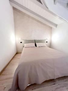 a white bedroom with a large white bed in it at Grazioso appartamento Aosta in Aosta