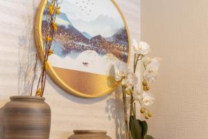 a mirror on a wall with a vase and flowers at Tsukiyume Kan - House with Parking, 10Mins to USJ, Tennoji, Namba in Osaka