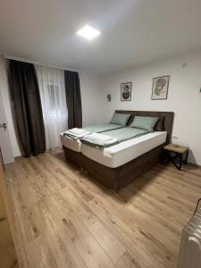 a bedroom with a large bed and a wooden floor at Apartman Antonovic in Valjevo