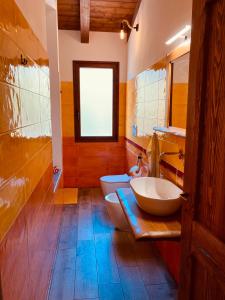 een badkamer met 2 wastafels, een toilet en een raam bij Coru & Bentu in Fluminimaggiore