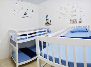 two white bunk beds in a white room at 575 Port Dickson # U Homestay - 2KM to Beach & Free Wifi in Port Dickson