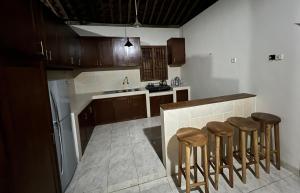 a kitchen with wooden cabinets and a counter with stools at Dream Village in Jarakan