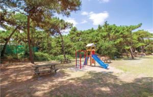 un parque infantil con un tobogán y un banco en un parque en Lovely Apartment In Rosolina Mare With Kitchen, en Rosolina Mare