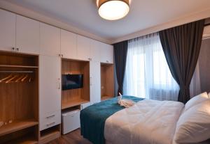 1 dormitorio con 1 cama grande y TV en Hotel Babi en Tiflis