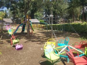 a playground with colorful play equipment in a park at Triple Eden Resort - Naivasha in Naivasha