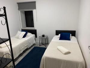 Cette chambre comprend deux lits et une petite table. dans l'établissement Zoe House, à Paul do Mar