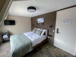 ein Schlafzimmer mit einem Bett in einem Zimmer mit einer Decke in der Unterkunft Hotel de Slapende Hollander in Kaatsheuvel