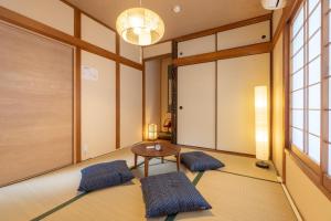 Zimmer mit einem Tisch und 2 Kissen in einem Zimmer in der Unterkunft Tsukiyume Kan - House with Parking, 10Mins to USJ, Tennoji, Namba in Osaka