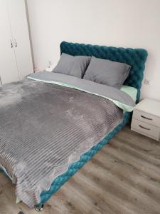 a bed with a blue headboard in a bedroom at Stari Hrast 2 in Prolomska Banja