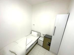 Habitación pequeña con cama y nevera. en Low Priced New Residential Rooms for rent in Dubai near DAFZA Metro Station, en Dubái