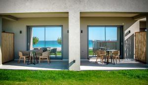 a patio with a table and chairs with a view of the ocean at Panorama Hotel in Falasarna
