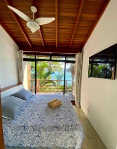 a bedroom with a bed with a ceiling fan at Casas Do Mar in Ilhabela