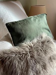 a pillow with a gray fuzzy pillowutenneauemetery at Das Bergquartier - Ferienwohnung Krottenkopf in Oberau