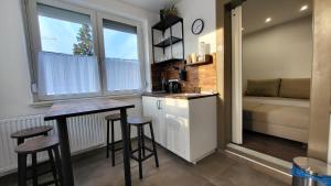 - une petite cuisine avec une table et des tabourets dans la chambre dans l'établissement Relax Apartments Sárvár A2, à Sárvár