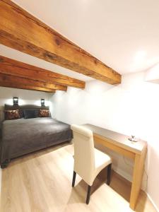 ein Schlafzimmer mit einem Bett und einem Schreibtisch mit einem Stuhl in der Unterkunft Mezzanine de Grinzing in Wien