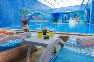 a room with a pool and a table and chairs at GRAND ANİ HOTEL in Kars