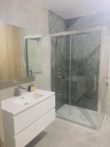 een badkamer met een witte wastafel en een douche bij Zen Ô Spa in Charleroi