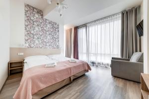 a bedroom with a bed and a chair at Kora Apartments in Prague
