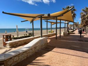 a boardwalk on the beach with a yellow umbrella at Bajo,Puebla Lucia,Fuengirola in Fuengirola