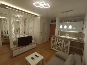 uma sala de estar com um sofá e uma televisão em Galija apartment em Belgrado