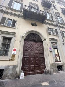 a building with a large brown door with a balcony at Lila House in Turin
