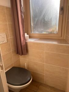 een badkamer met een zwart toilet en een raam bij gites de Warincthun in Audinghen